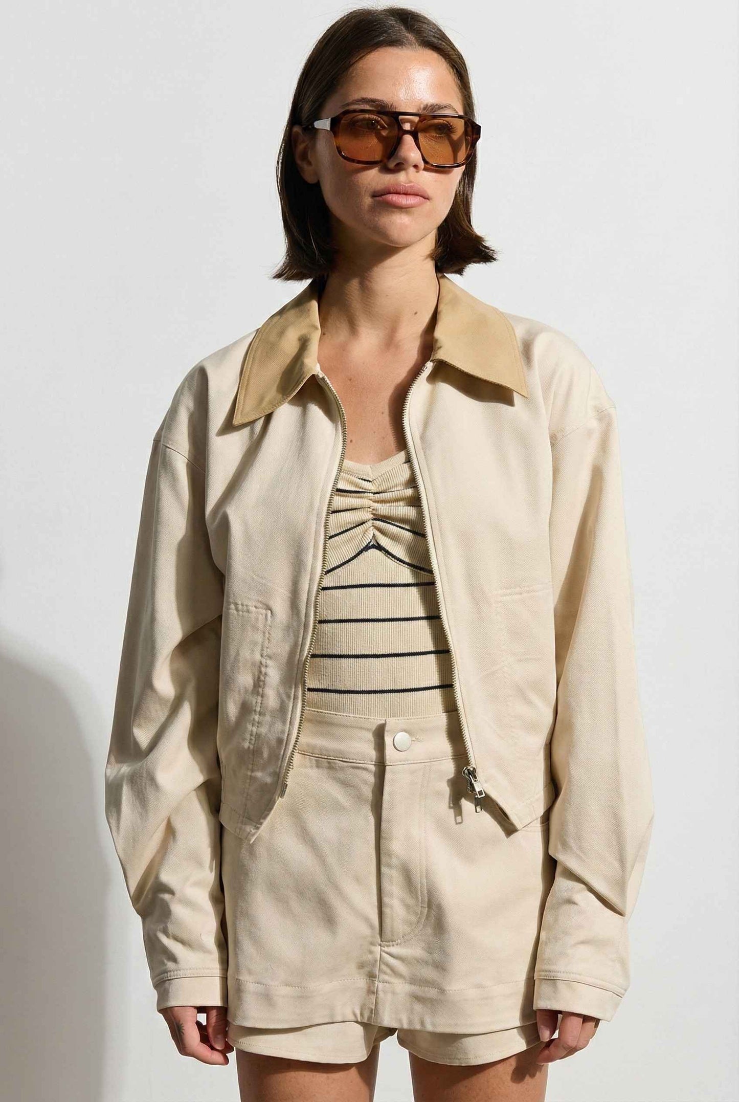 Model wearing Arlo Jacket | Beige Lyocell-Blend Jacket with Contrast Collar with striped shirt and shorts