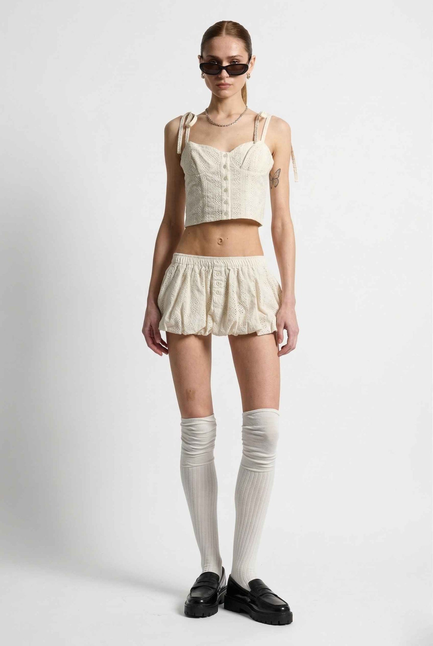 Woman wearing a Chloe Skirt Cream Cotton Eyelet Bubble Hem Mini Skirt on a white background