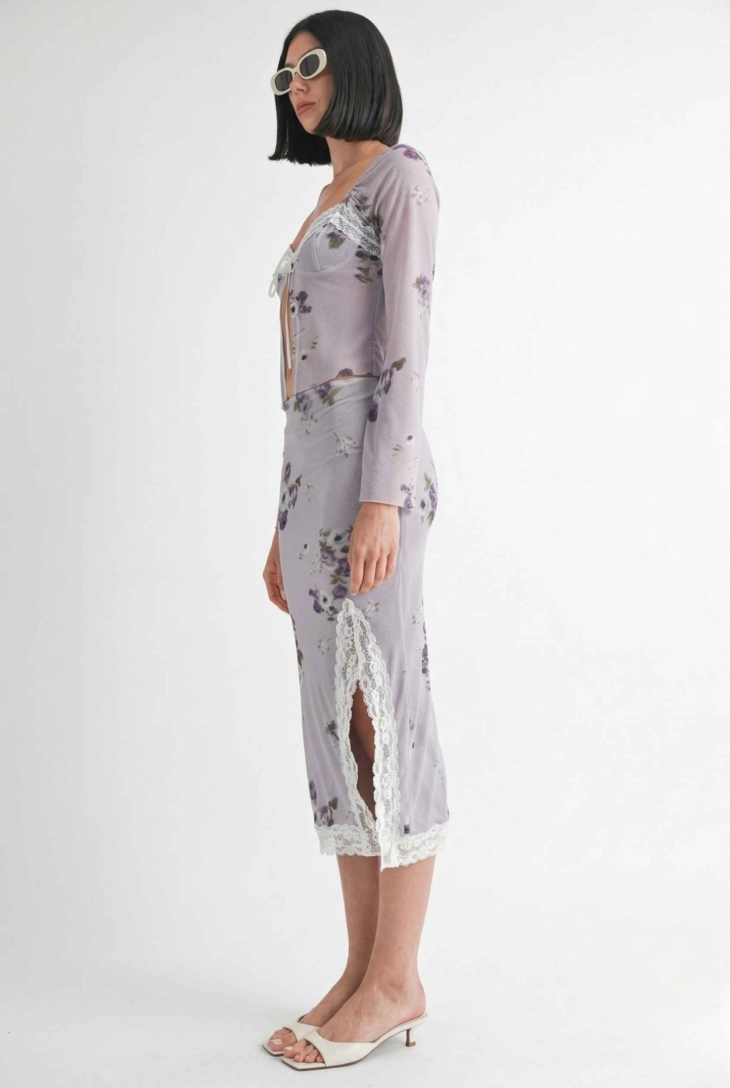 Woman wearing a Elara Skirt Lilac Floral Mesh Midi Skirt with Lace Slit with a sheer overlay on a white background