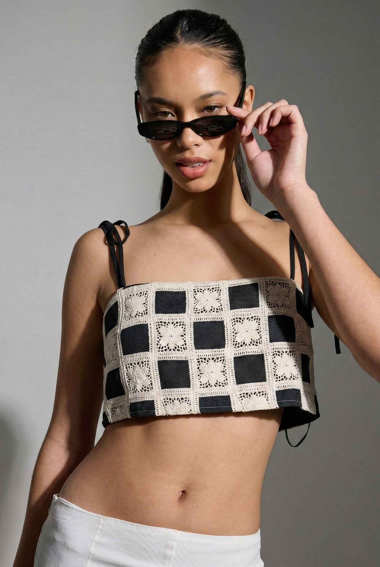 Model wearing Elodie Top in Black Jacquard Square Neck Cami with Ribbon Tie Straps with capri pants on a plain background