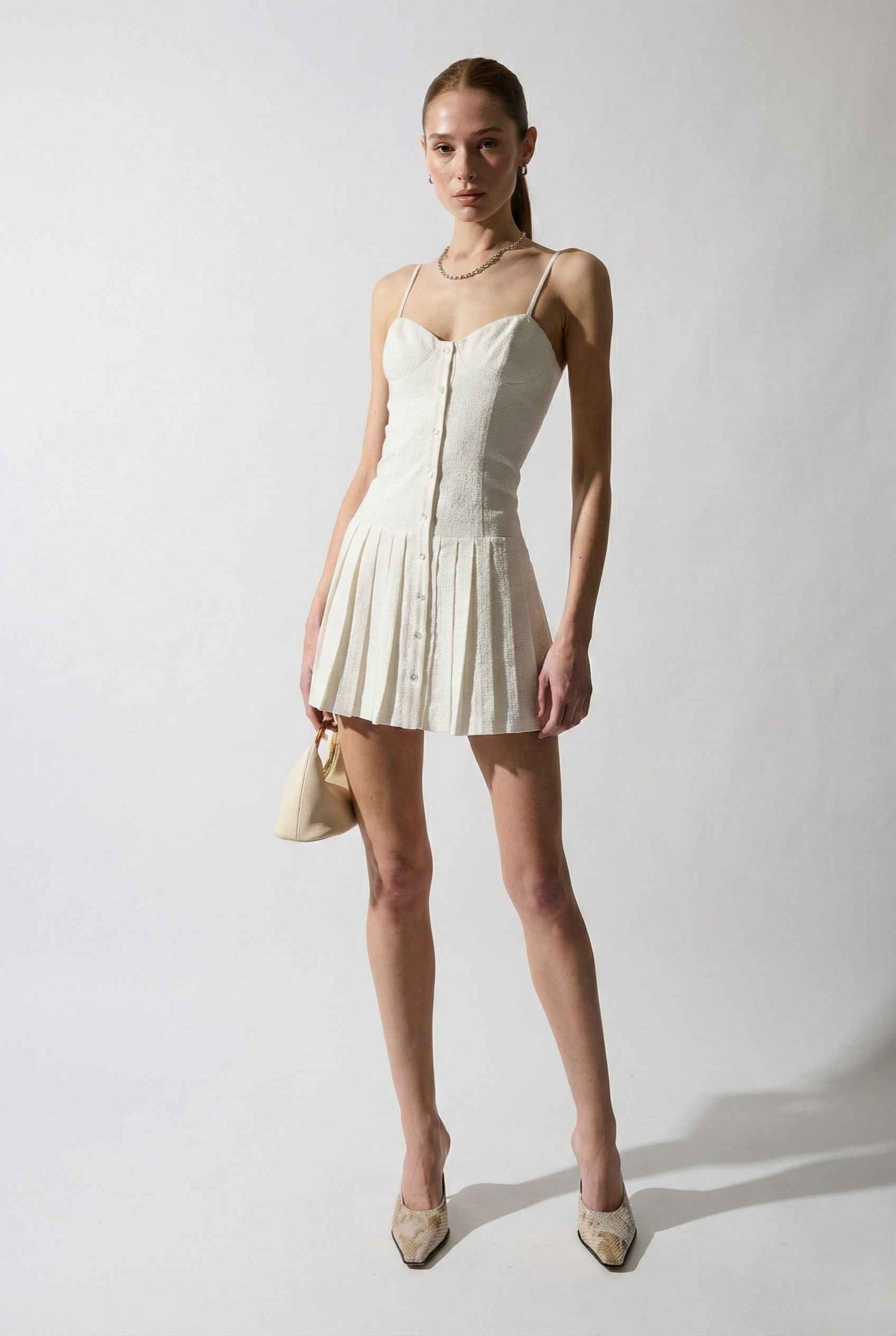 Woman wearing a Eloise Mini White Linen Blend Button Front Dress with a plain background