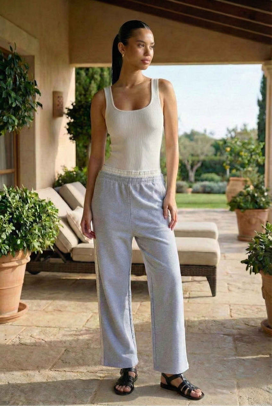 Model wearing Jamie Pants in Blue Double-Waist Boxer Style Trousers with basic tank top and sandals standing on luxury patio