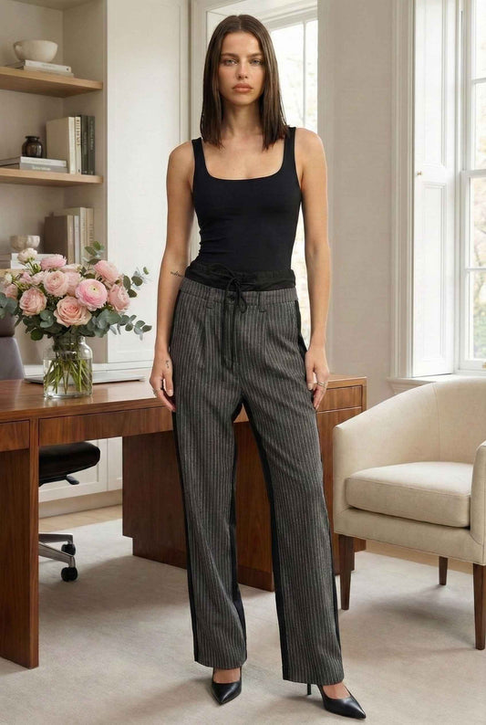 Model wearing Jett Pants in Grey Pinstripe Mixed-Media Trousers with tank top and pumps standing in luxury office
