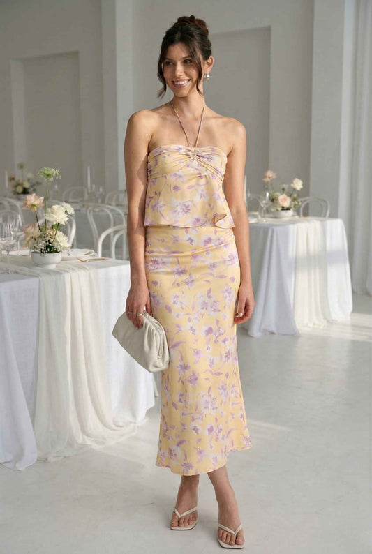 Woman wearing a Liliana Top Yellow & Lilac Floral Halter Peplum at a wedding reception.