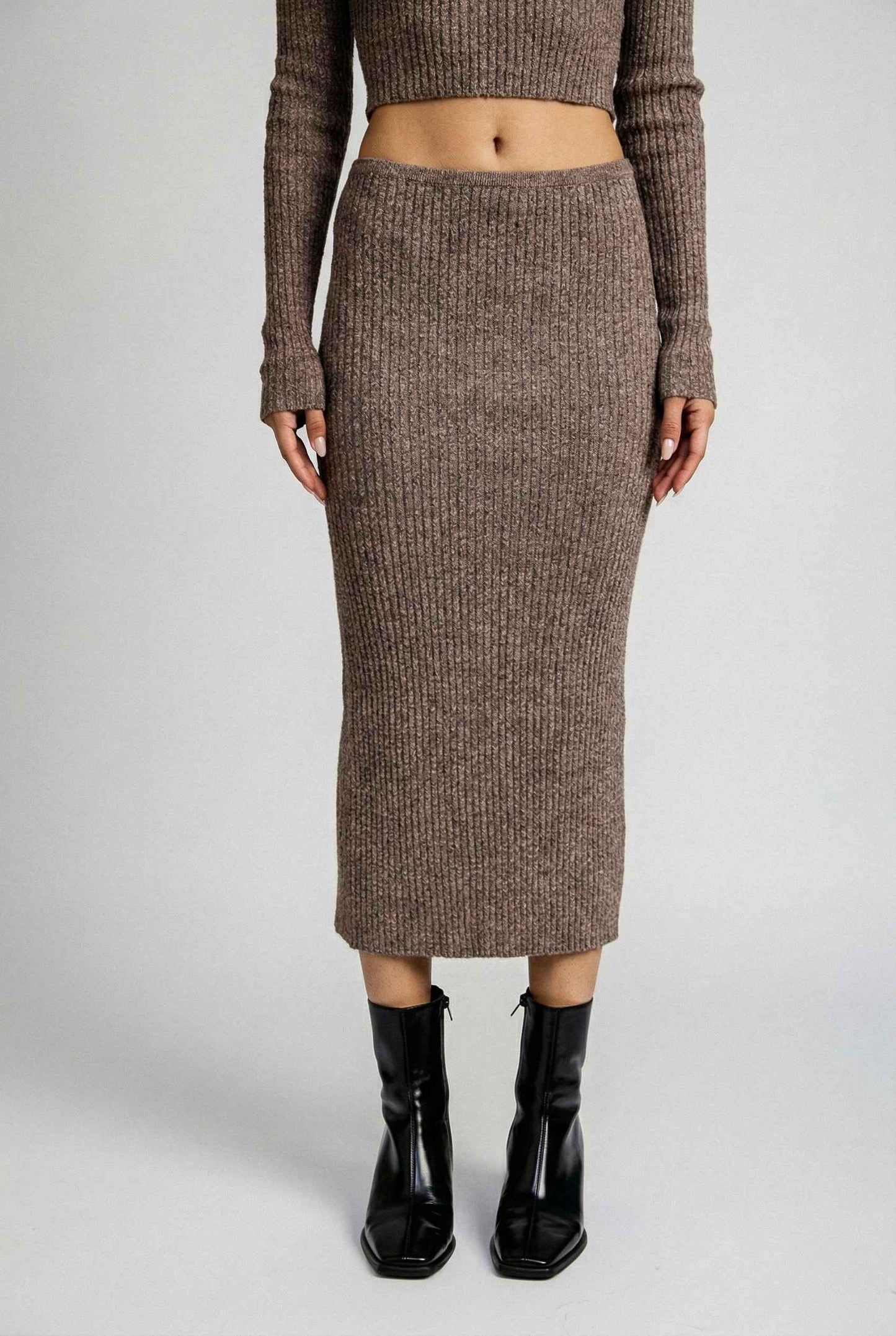 Model wearing Mila Skirt Marled Ribbed Knit Column Maxi Skirt in Brown with matching sweater top and heeled boots on a plain background