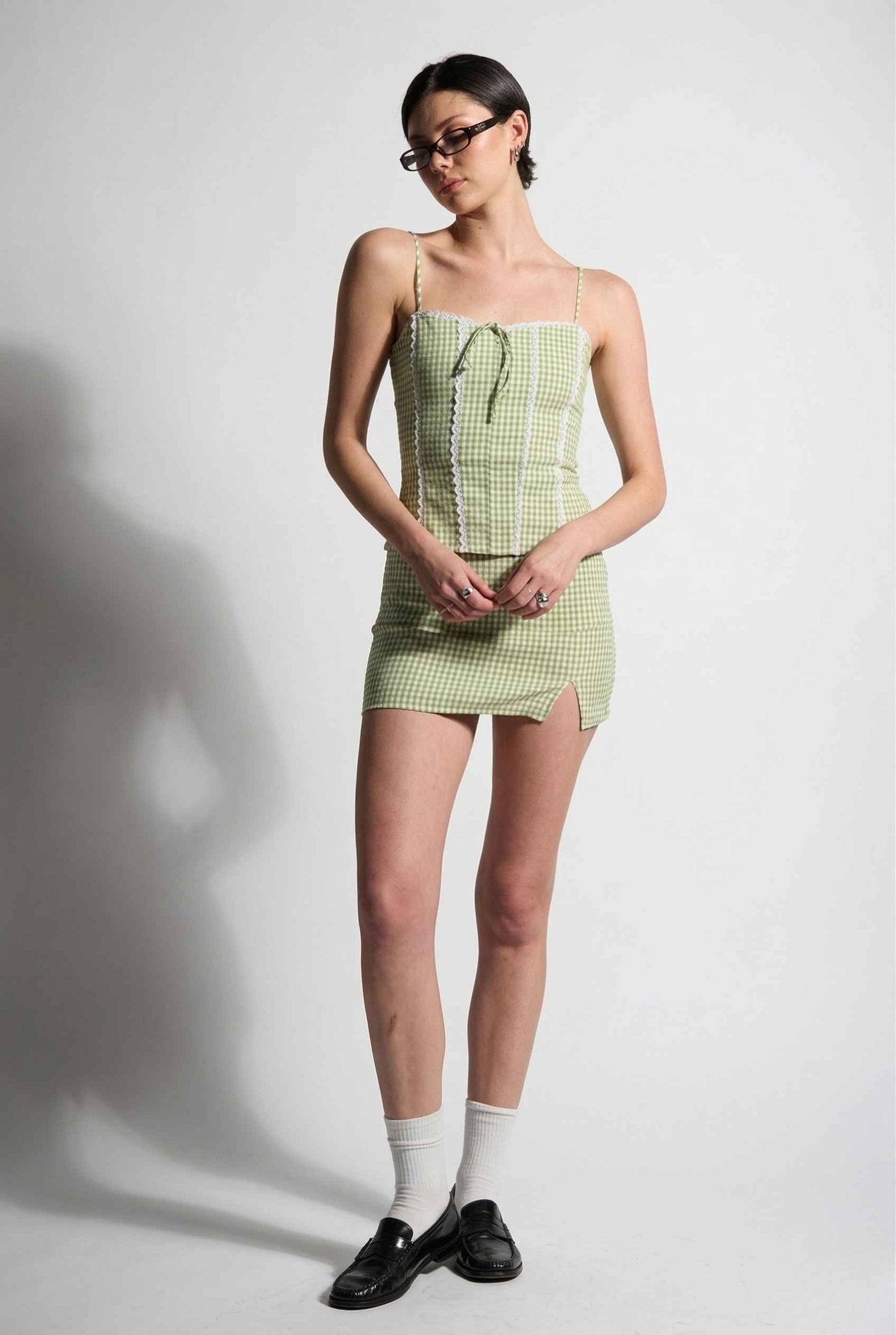 Woman wearing a Piper Top Green Gingham Lace Trim Corset Cami against a white background