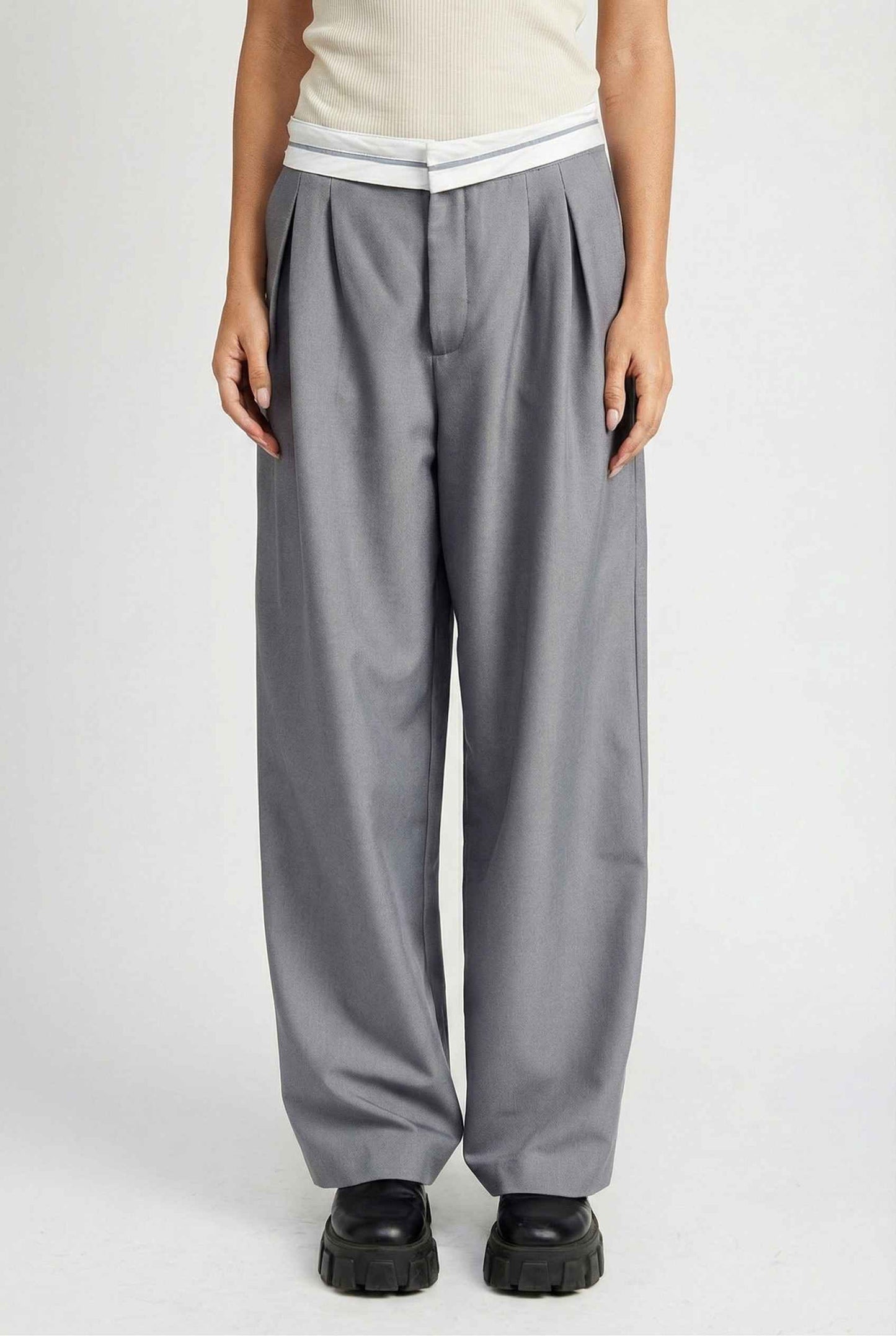 Model wearing Remi Pants in Grey Tailored Trousers with Contrast Fold-Over Waistband paired with basic tank and loafers