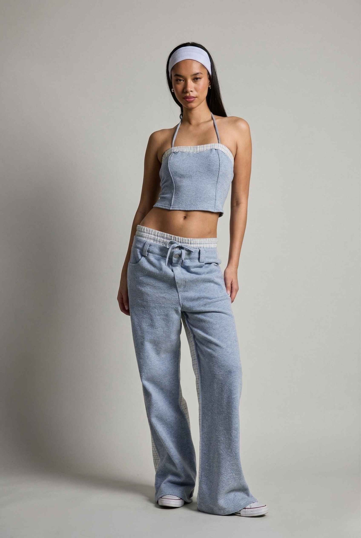 Woman wearing a Riley Top Light Blue Heathered Halter with Plaid Trim and wide-leg pants on a plain background