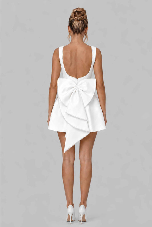 Virtual model wearing The Noémi Pearl Bow Dress Pearl-Trimmed Statement Bow Mini Dress in White