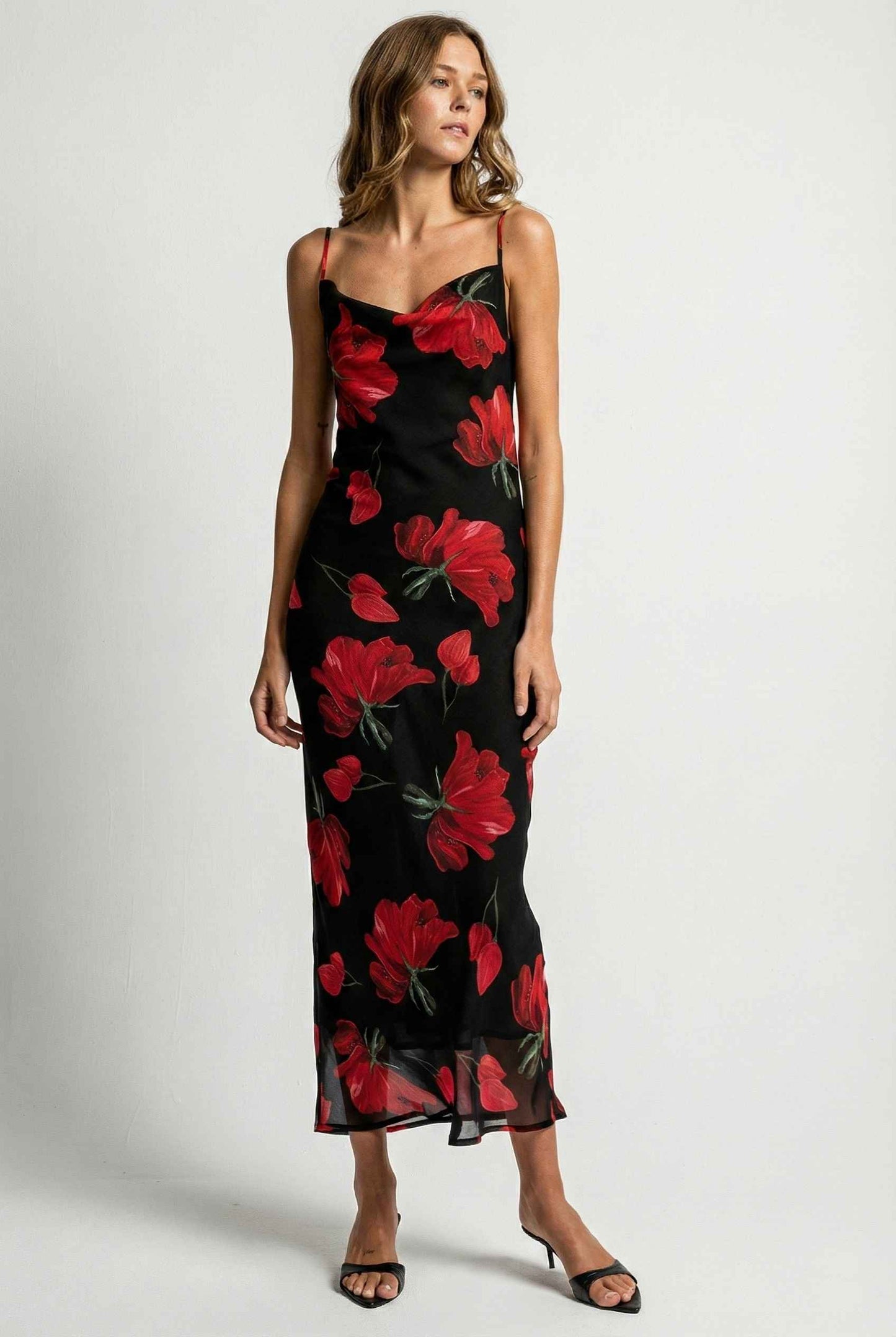 Woman wearing a Valentina Maxi Black Cowl Neck Floral Mesh Dress with red floral pattern on a white background