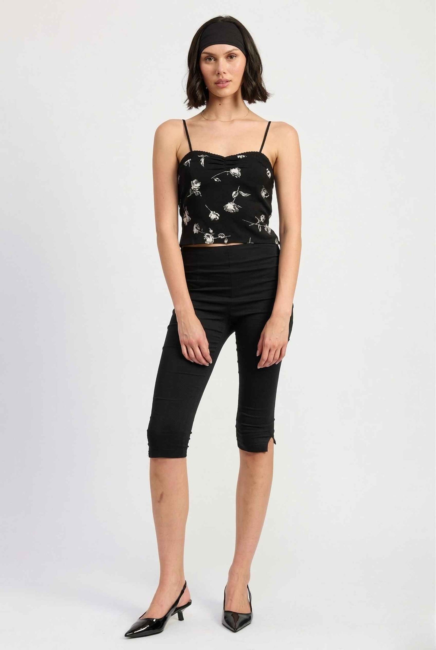 Woman wearing a Zara Top Black & White Rose Print Cotton Lace Trim Camisole and black pants on a white background