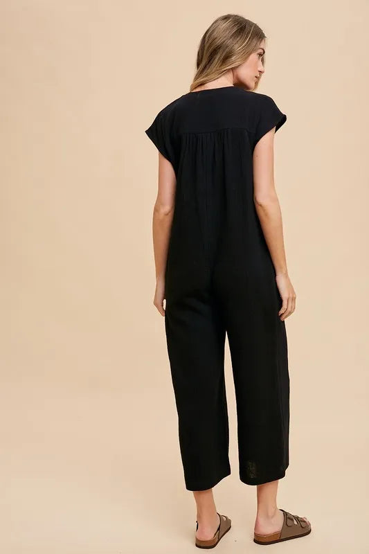 Annie Wear Button Detail Wide Leg Jumpsuit with Pockets in Black, featuring a relaxed fit and cap sleeves