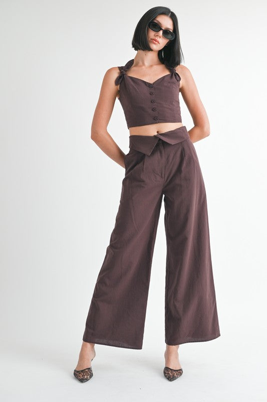 Emory Park Button Up Cropped Top With Shoulder Ties in dark brown worn with matching high-waisted wide-leg pants