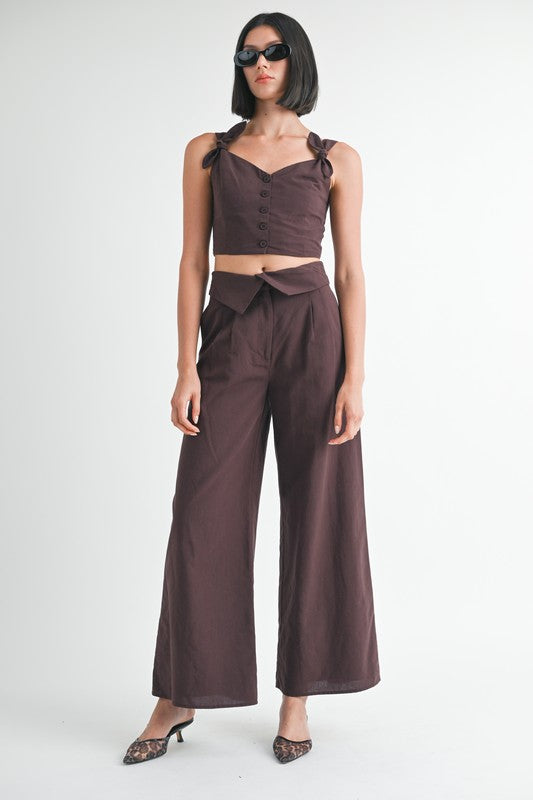 Emory Park Button Up Cropped Top With Shoulder Ties in dark brown paired with high-waisted wide-leg pants