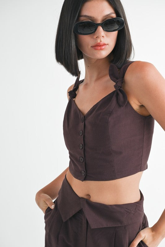 Emory Park Button Up Cropped Top With Shoulder Ties in dark brown worn by model with sunglasses close up