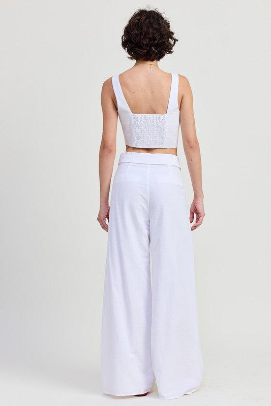 Back view of Emory Park Button Up Cropped Top With Shoulder Ties in white paired with wide-leg white pants