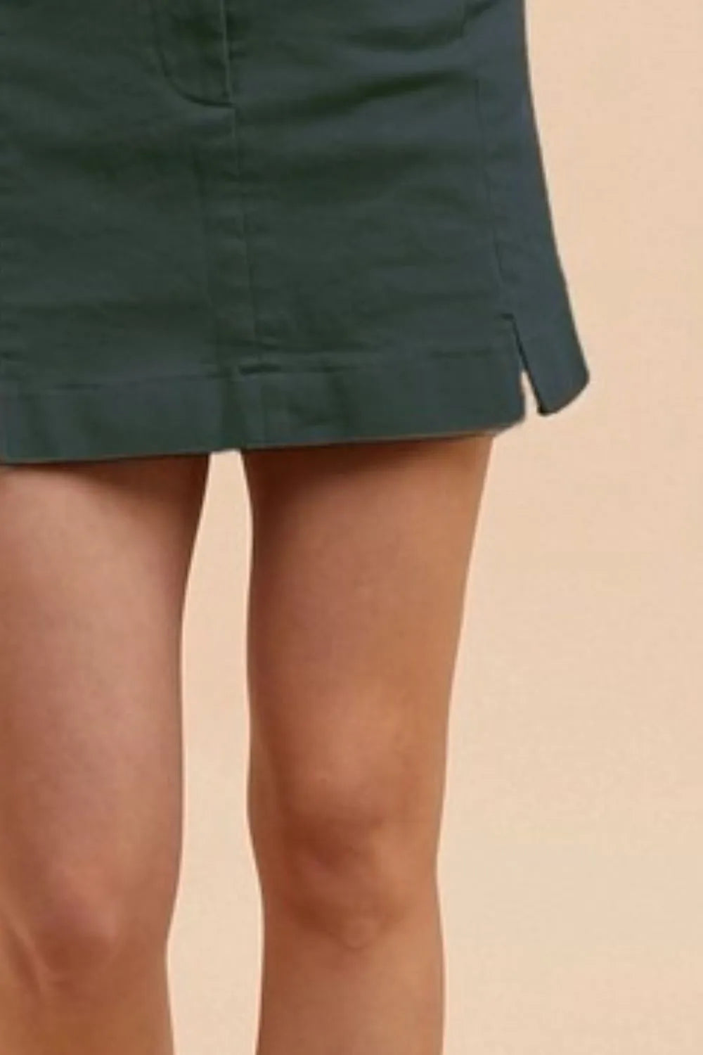 Cotton Mini Skirt in green featuring a sleek design and side slits for added style