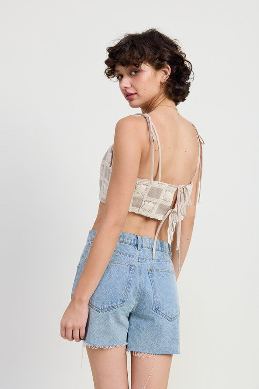 Woman wearing a beige Cropped Crochet Top by Emory Park paired with light blue denim shorts