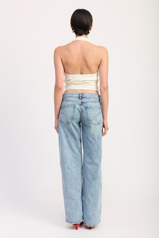Back view of a model wearing Emory Park cropped halter top with lace detail and light blue high-waisted jeans