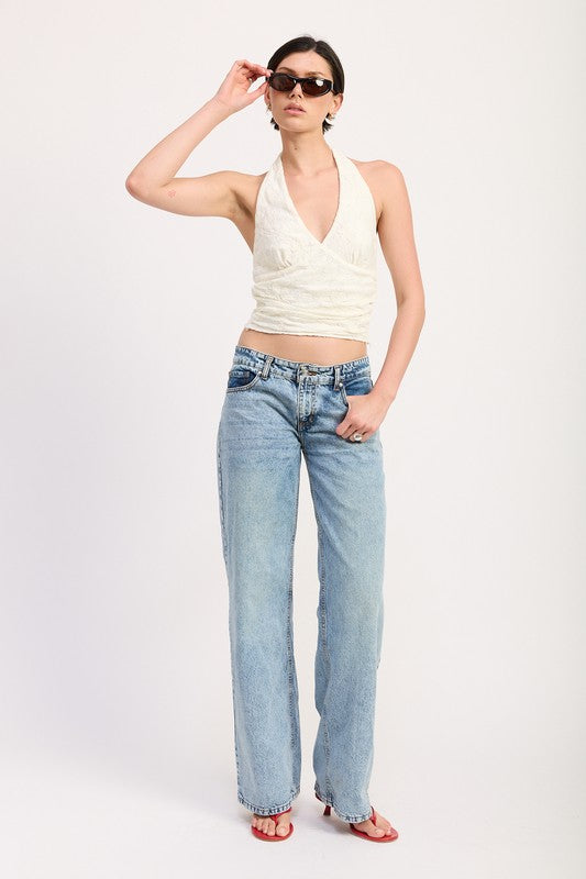 Woman wearing Emory Park Cropped Halter Top With Lace Detail paired with light wash jeans and sunglasses