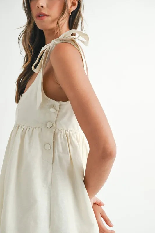 Embroidered mini dress in light fabric with shoulder ties and button details