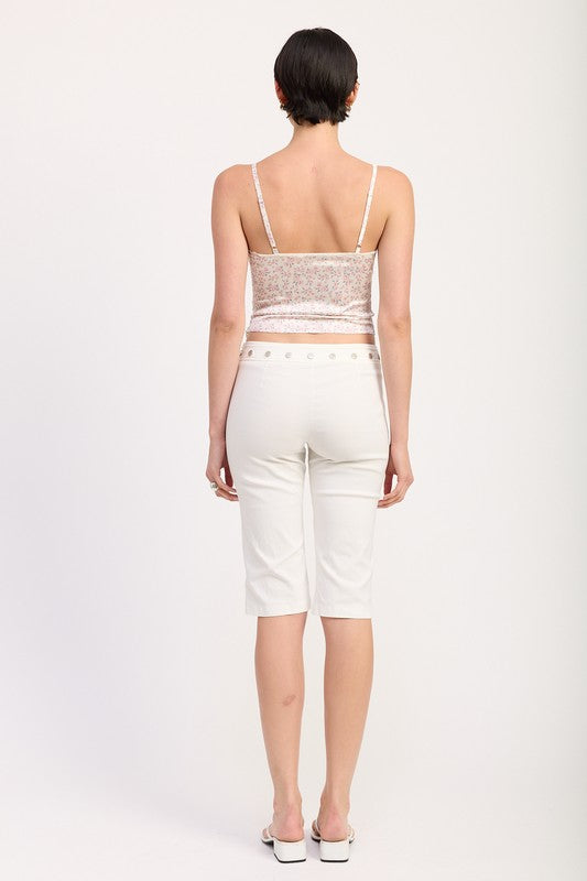 Back view of model wearing Emory Park Floral Satin Cami Top with Lace Trim and white cropped pants
