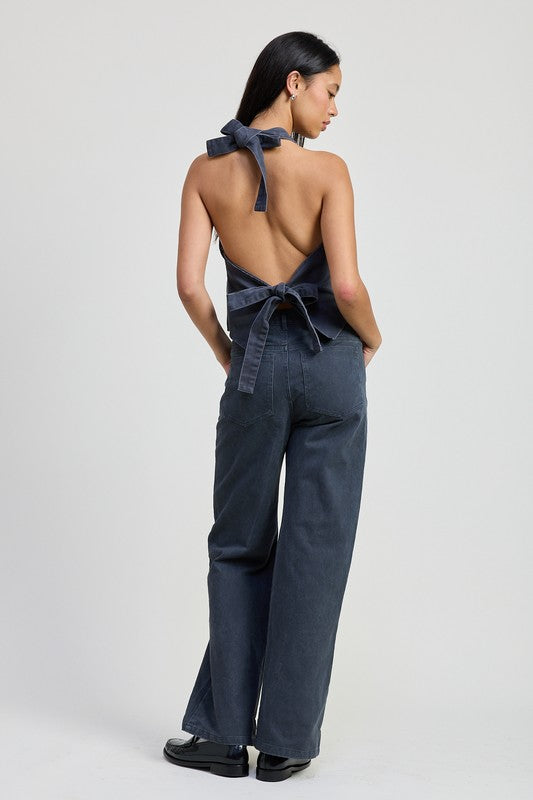 Back view of model wearing Emory Park folded fitted denim pants with dark wash and wide-leg fit
