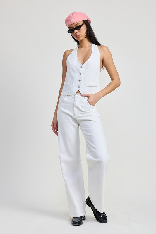Model wearing Emory Park folded fitted denim pants in white paired with a white vest and pink beret