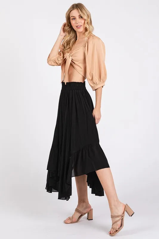 Fashionable handkerchief hem midi skirt in black paired with a stylish top and heels