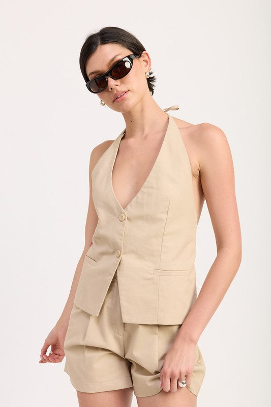 Emory Park beige high waisted pleated shorts styled with matching sleeveless vest and sunglasses