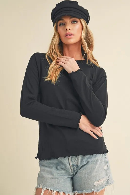 Model wearing a black Lettuce Hem Long Sleeve Shirt paired with distressed denim shorts