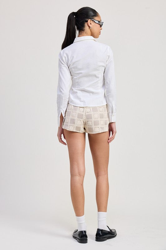 Rear view of woman wearing Emory Park Mini Jacquard Crochet Shorts with white button-up shirt and black shoes