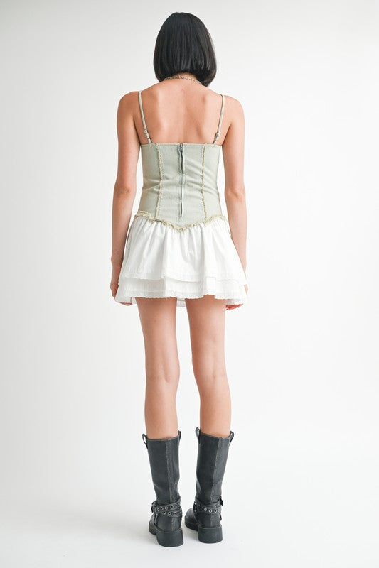 Back view of model wearing Emory Park Mini Sleeveless Denim Dress with white skirt and black boots