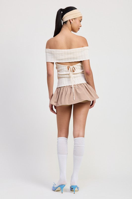 Emory Park off shoulder sweater top in white ribbed knit with back tie detail styled with beige skirt and white knee-high socks