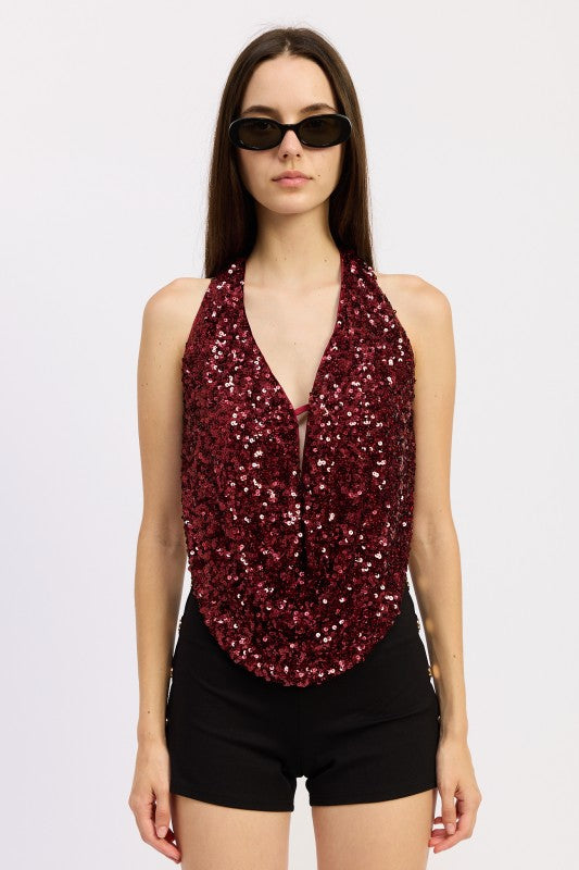 Fashionable woman wearing a burgundy Sequin Cowl Drape Halter Top paired with black shorts