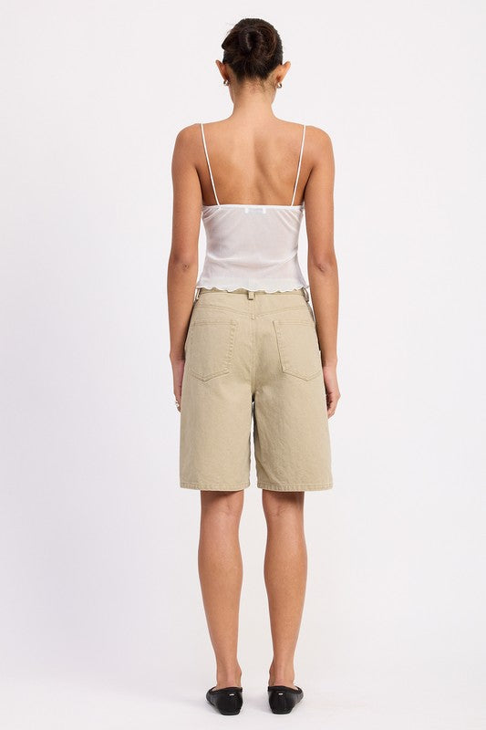 Model back view wearing Sheer Mesh Floral Cup Cami Top in white with beige Bermuda shorts and black flats