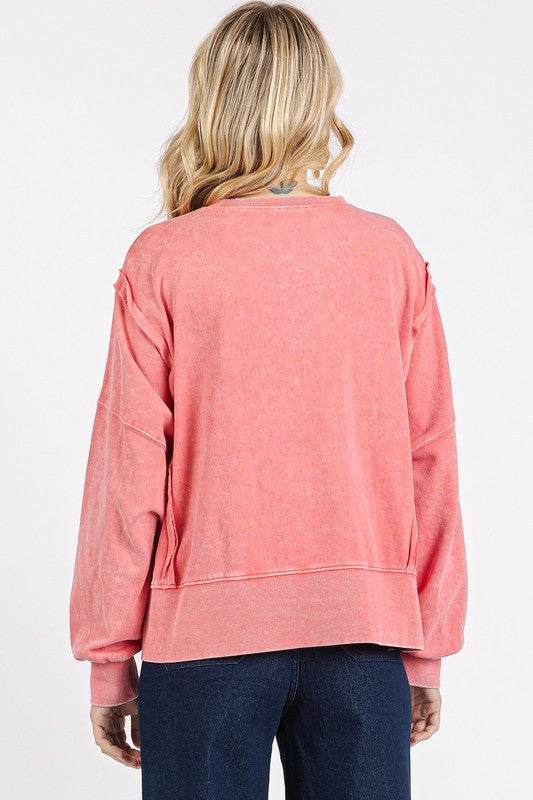 Back view of a coral Side Slide Exposed Seam Sweatshirt with relaxed fit and soft fabric