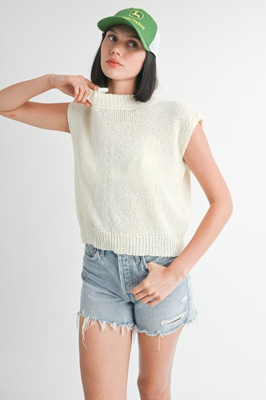 Emory Park sleeveless sweater top in cream worn with denim shorts and green cap