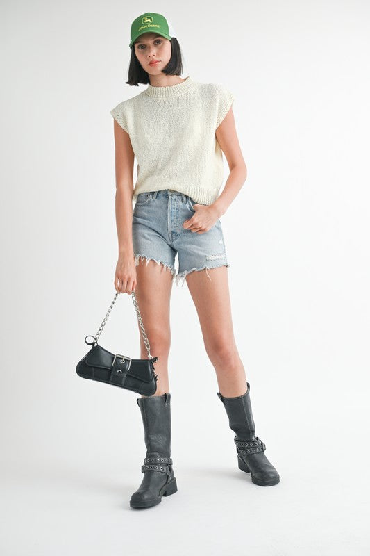 Emory Park sleeveless sweater top in cream worn with denim shorts black boots and green cap