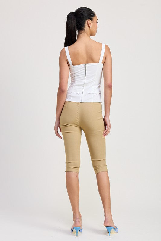 Back view of model wearing white Emory Park Square Neck Corset Top with beige cropped pants and blue heels