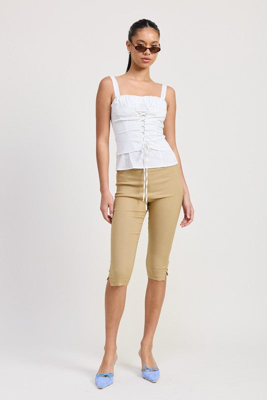 Emory Park white Square Neck Corset Top with front lace-up detail worn with beige capri pants and blue heels