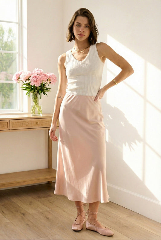 Model wearing Emory Park V-Neck Sleeveless Rib Tank Top in white with satin midi skirt ballet flats standing in minimalist room with flowers