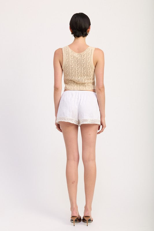 Emory Park Crochet Button Front Vest Top in beige shown from the back on a model wearing white shorts