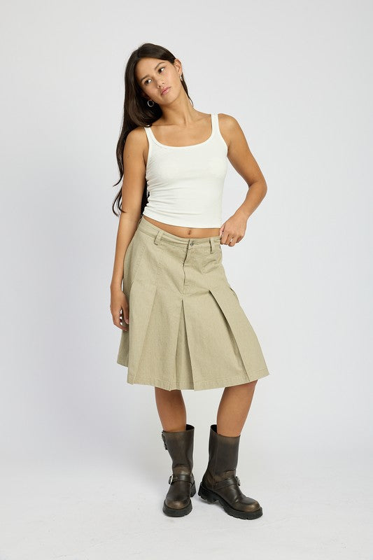 Emory Park knee length pleated skirt in beige styled with white tank top and black boots