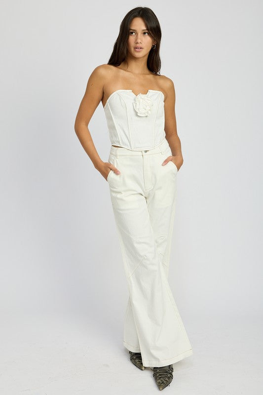 Emory Park High Waisted Wide Leg Pants in white worn by model with strapless top and hands in pockets