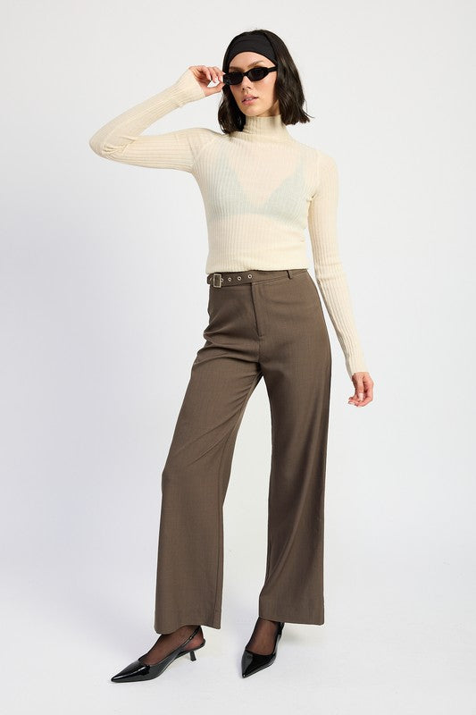 Model wearing Emory Park brown wide leg Trouser Pants With Adjustable Waist Buckle paired with cream ribbed turtleneck and black heels