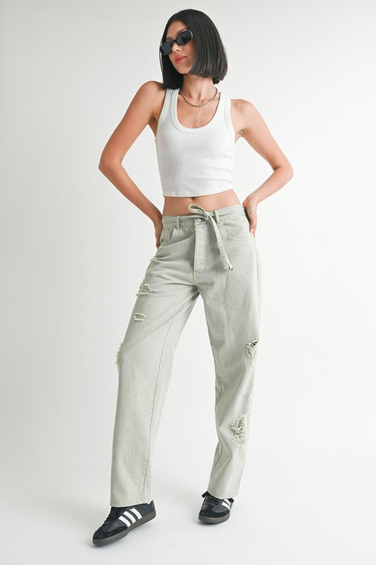 Emory Park distressed wide leg pants in light gray worn with white tank top and black sneakers