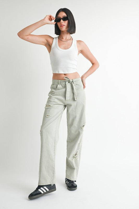 Emory Park Distressed Wide Leg Pants in light olive green worn with white tank top and black sneakers