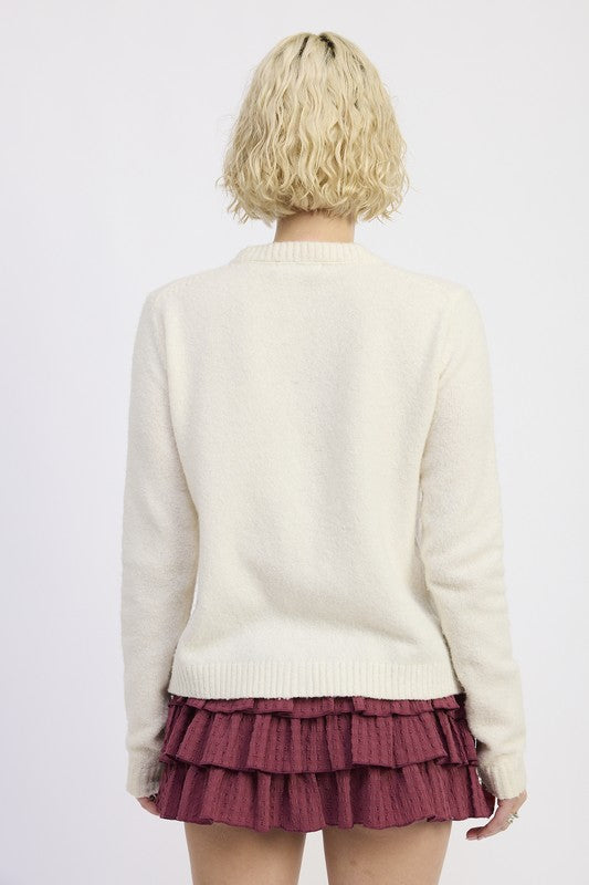 Emory Park Fitted Button-Up Cardigan in cream color, viewed from the back, paired with a ruffled skirt