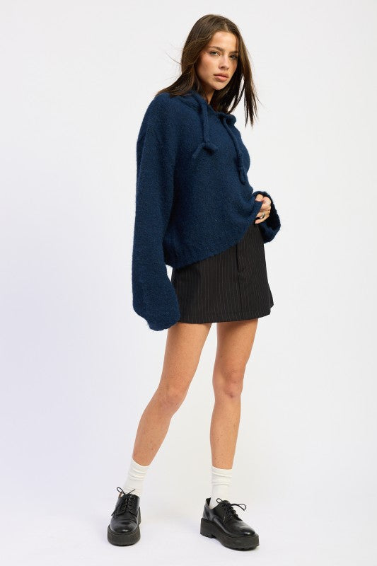 Emory Park Fringe Hoodie With Drawstrings in navy paired with a pleated skirt for a stylish look